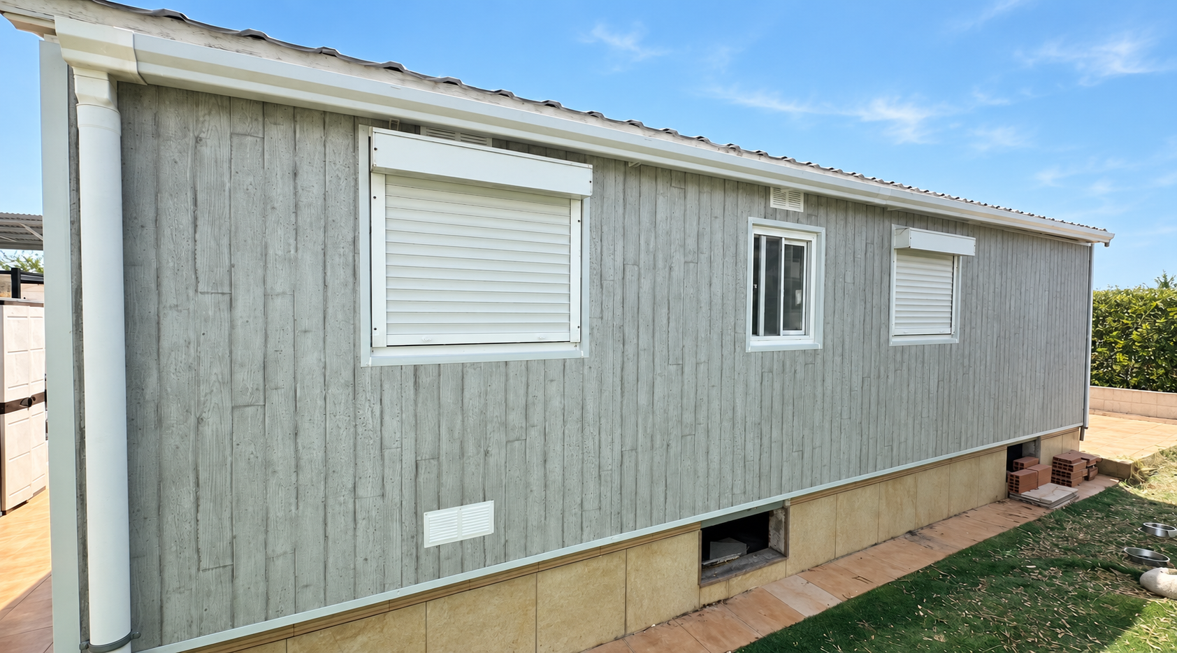 Revestimiento exterior vertical con acabado gris y remates blancos